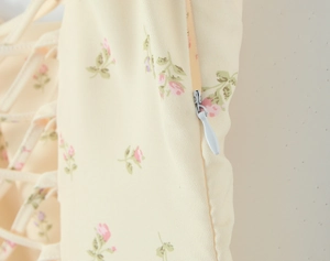 Detail of yellow floral dress showing invisible zipper and back lace-up closure