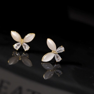 Elegant butterfly stud earrings with opal texture and zircons on black surface