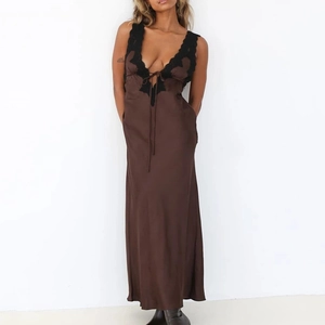Vue détaillée du col en V avec dentelle noire sur cette robe longue en soie marron