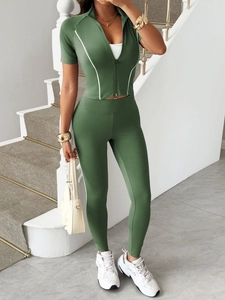 Detailansicht grünes Y2K Sport-Set mit Reißverschluss-Top, Leggings und weißen Seitenstreifen