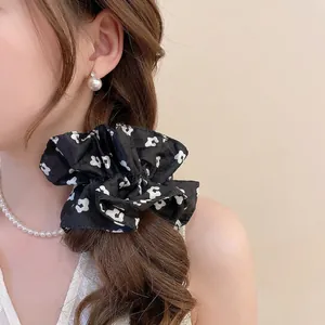 Floral black satin oversized scrunchie for women tied on elegant long wavy brown hair