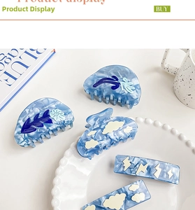 Blue marble acetate hair claw set including cloud and floral clips on a white ceramic plate