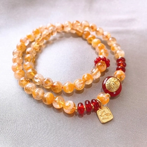 Detail of beaded lily-of-the-valley bracelet with orange crystals and gold accents