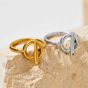 Minimalist OT toggle rings in gold and silver finish on a natural stone background