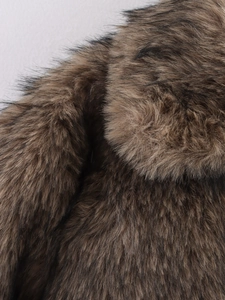 Detailansicht der braunen Kunstfell-Textur mit schwarzen Spitzen einer Winterjacke
