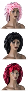 Detailed view of satin bonnet set in pink, black, and wine red with large bow decorations
