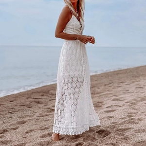 White bohemian lace V-neck jumpsuit with hollow details on a tropical beach setting