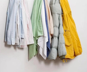 Detail showing various garments and towels hanging on sturdy oversized wall hooks
