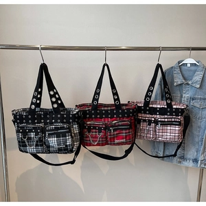 Detailed view of punk plaid tote bags with rivets, metal chains and zipper pockets
