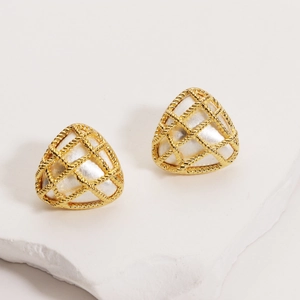 Macro detail of gold plated triangle earrings with mother of pearl inlay on marble