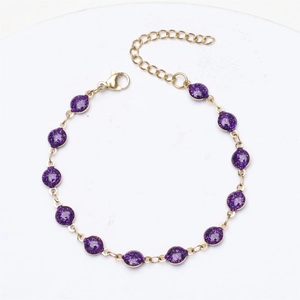 Detail of adjustable gold-plated chain bracelet with purple glitter enamel round charms