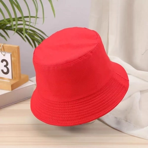 Detail of red cotton bucket hat shown in a natural lifestyle setting with home decor