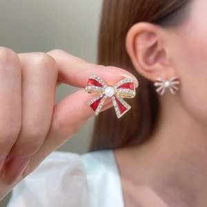 Elegant red bow stud earrings with sparkling crystals and pearl accent in gold finish