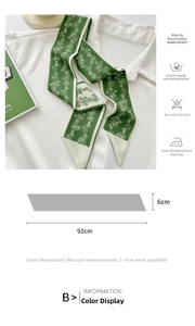 Detailed view of green floral twilly silk scarf worn on collar with size dimensions