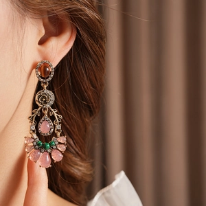 Close-up of vintage flower teardrop earrings with multi-colored crystals on a model