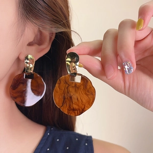 Detailed view of retro marbled amber resin earrings featuring textured gold-tone studs