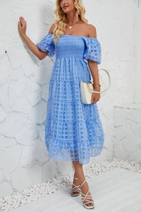 Close-up of light blue layered summer dress showing textured square pattern and smocking