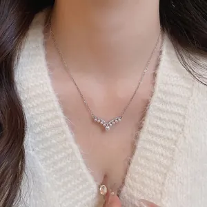 Elegant V-shaped silver necklace with white pearls and cubic zirconia on a female model