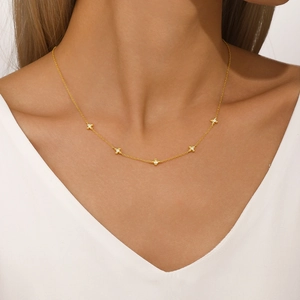 Close-up of a gold 925 sterling silver four-leaf clover heart necklace worn on neck