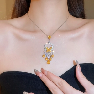 Detail view of silver necklace featuring yellow crystals and a butterfly pendant on a model