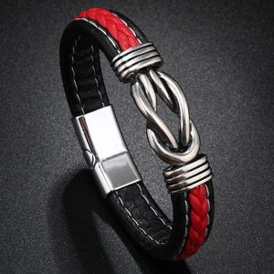 Close-up of woven red and black leather bracelet with magnetic knot design on dark background
