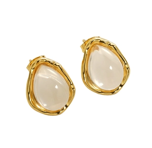 Detailed view of teardrop earrings with textured gold metal frame and translucent stones