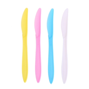 Close-up of colorful disposable plastic knives for unicorn theme party tableware sets