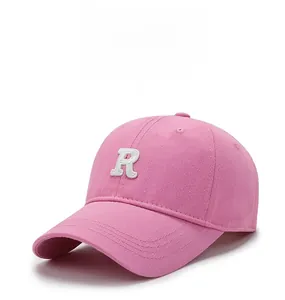 Detail of pink cotton baseball cap with white 3D embroidered letter R on front