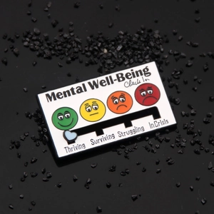 Close-up of sliding mental health enamel pin with thriving to crisis mood indicators