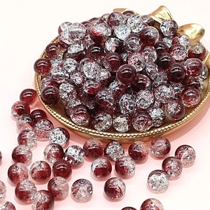 Close-up of 10mm wine red crackle glass beads in a gold tray for DIY jewelry making
