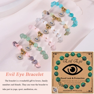 Pink zebra stone Evil Eye charm bracelet on display with Good Luck protection card