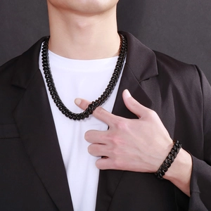 Male model wearing a black stainless steel Cuban chain necklace and bracelet set