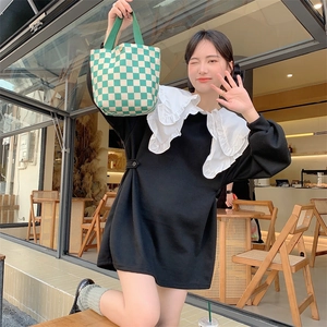 Close-up of green and white checkered corduroy tote bag styled with a vintage black top