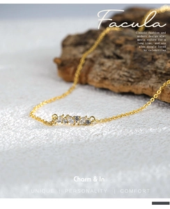 Macro shot of a gold necklace featuring sparkling marquise and round-cut cubic zirconia