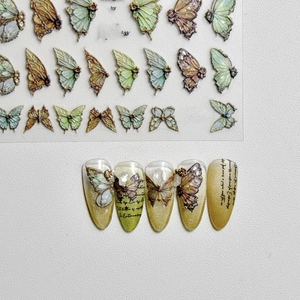 Embossed green swallowtail butterfly nail art stickers on long yellow almond nails