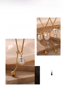 Detail einer goldenen Schlangenkette mit großer weißer Perle und polierter Goldperle