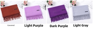 Close-up of fringe edges and Cashmere labels on caramel and purple winter scarves