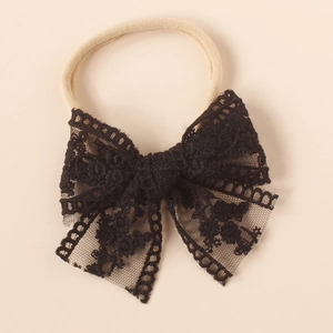 Close-up of black lace bow headband with intricate embroidery on elastic nylon band