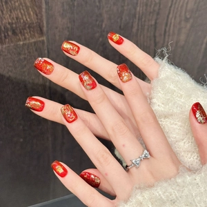 Festive red press-on nails with gold foil and Chinese traditional patterns on hands