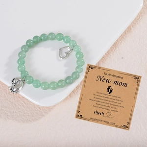 Detail of beaded pink zebra stone bracelet with silver baby feet and heart charm for new moms