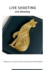 Detailed view of a vintage leopard brooch with intricate textured engraving on gold alloy