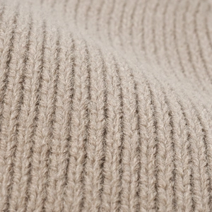 Detailed knit texture of a beige thick ribbed beanie for autumn winter warmth