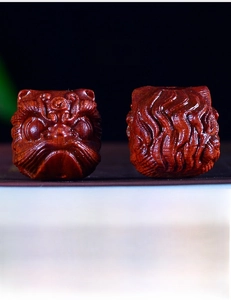 Macro shot of handcrafted red sandalwood lion carvings showing natural wood grain detail