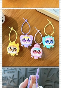 Lot de quatre porte-clés squishy mignons à grands yeux sur un fond de bois naturel