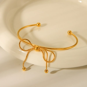 18K gold stainless steel open bangle featuring a woven bow design and bead accents