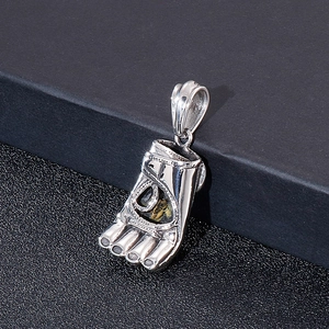 Macro shot of silver sandal foot pendant with polished metal finish on black background