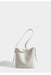 Detail view of white bucket bag featuring adjustable side straps and smooth leather texture