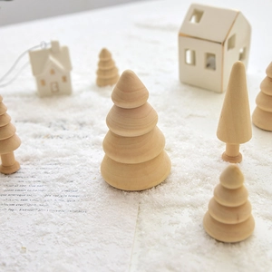 Minimalist wooden Christmas tree ornaments featuring natural wood textures on a snowy background