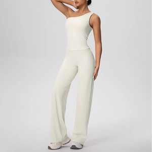 Détail du haut de yoga à une épaule blanc cassé et du pantalon de fitness large taille haute