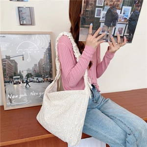 Detail of cream daisy canvas tote bag featuring stylish ruched shoulder strap detail